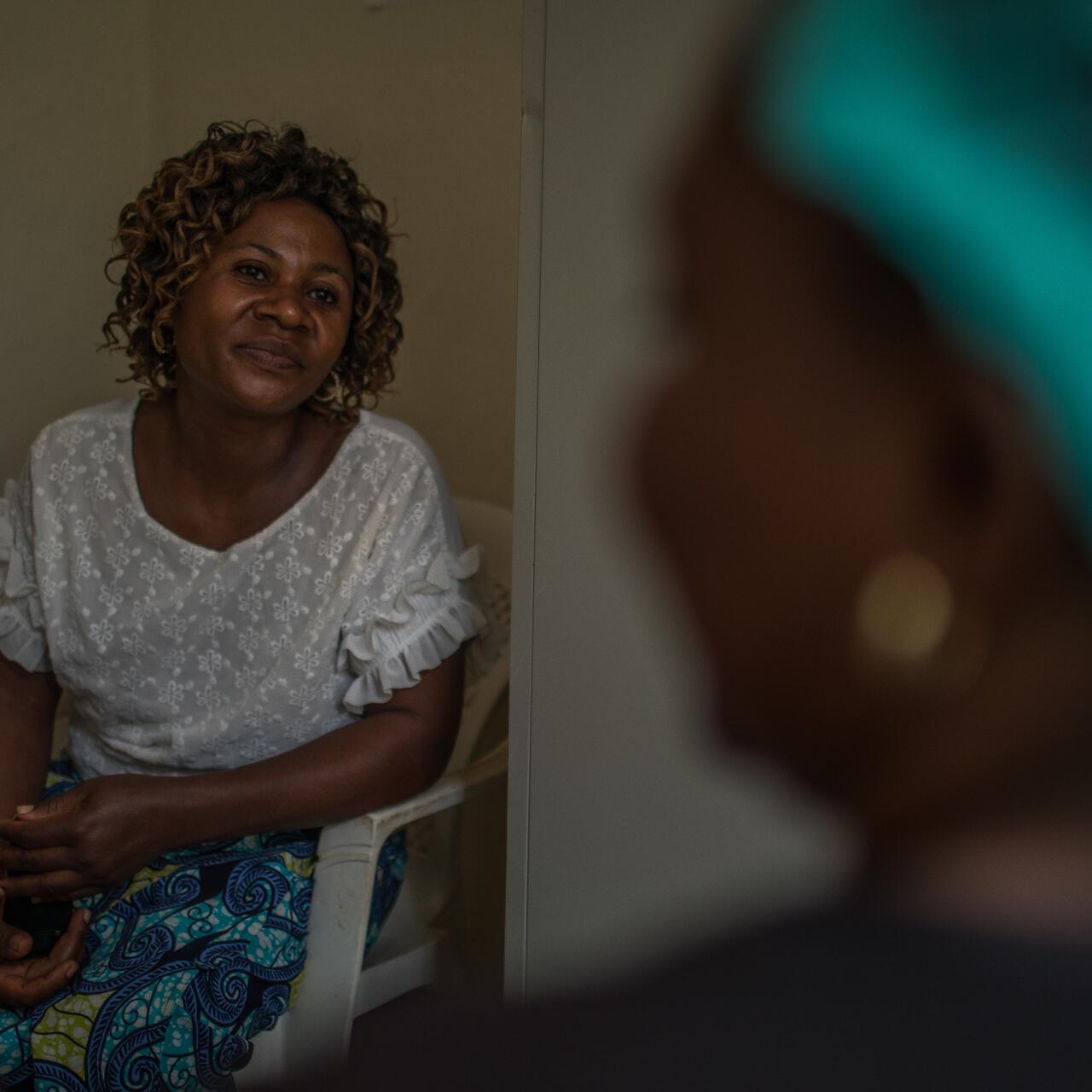 An Ebola survivor in Congo receives mental health support from International Rescue Committee staff member seated across from her.