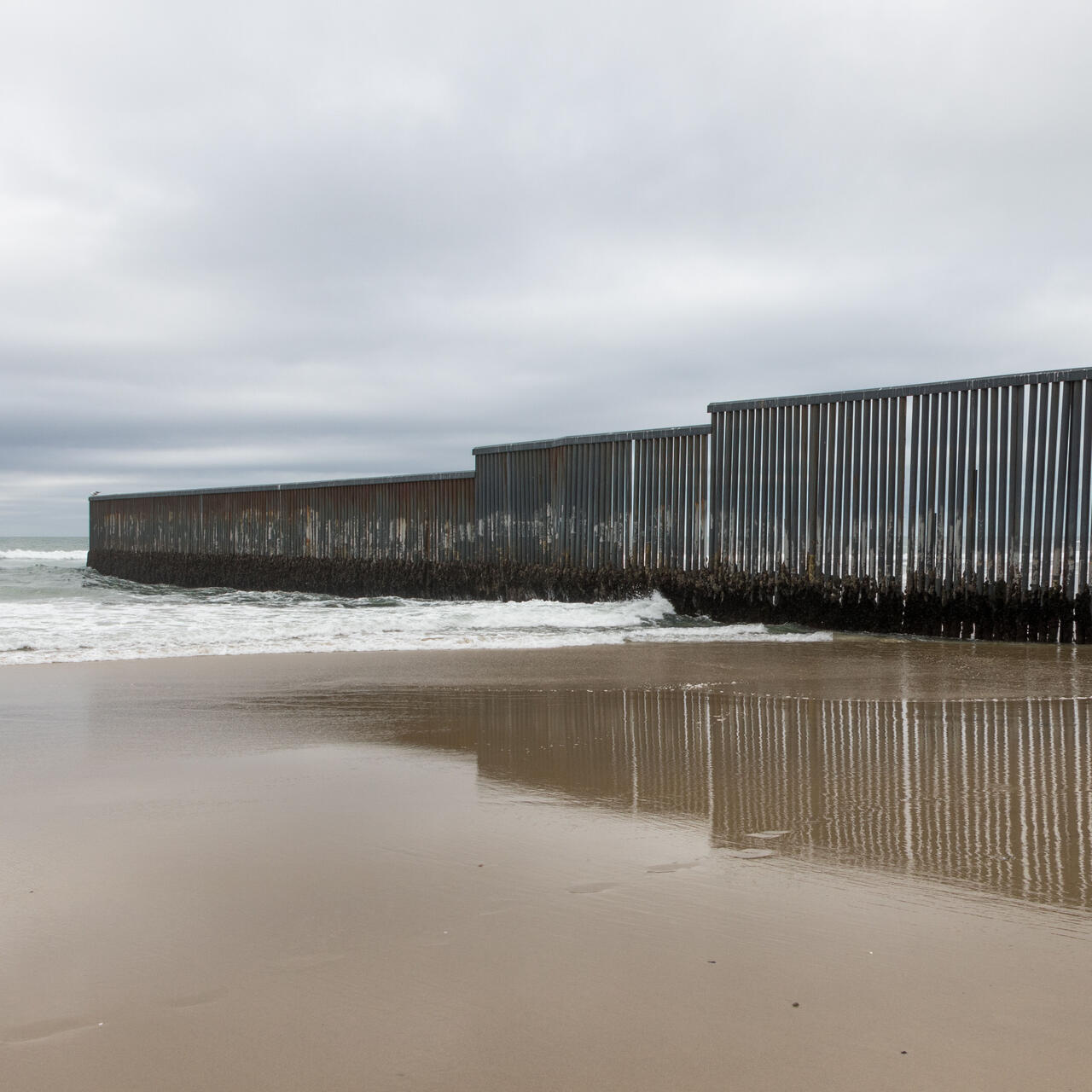 En una playa en la frontera entre Estados Unidos y México en Tijuana, México, un muro fronterizo se extiende hacia el océano.