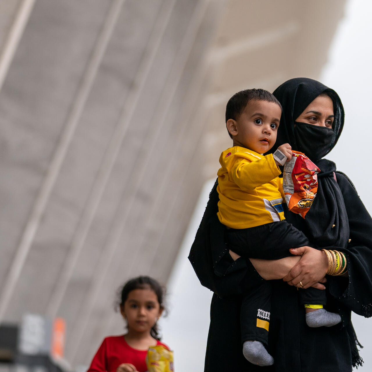 An Afghan woman holds her son as they arrive in the U.S.