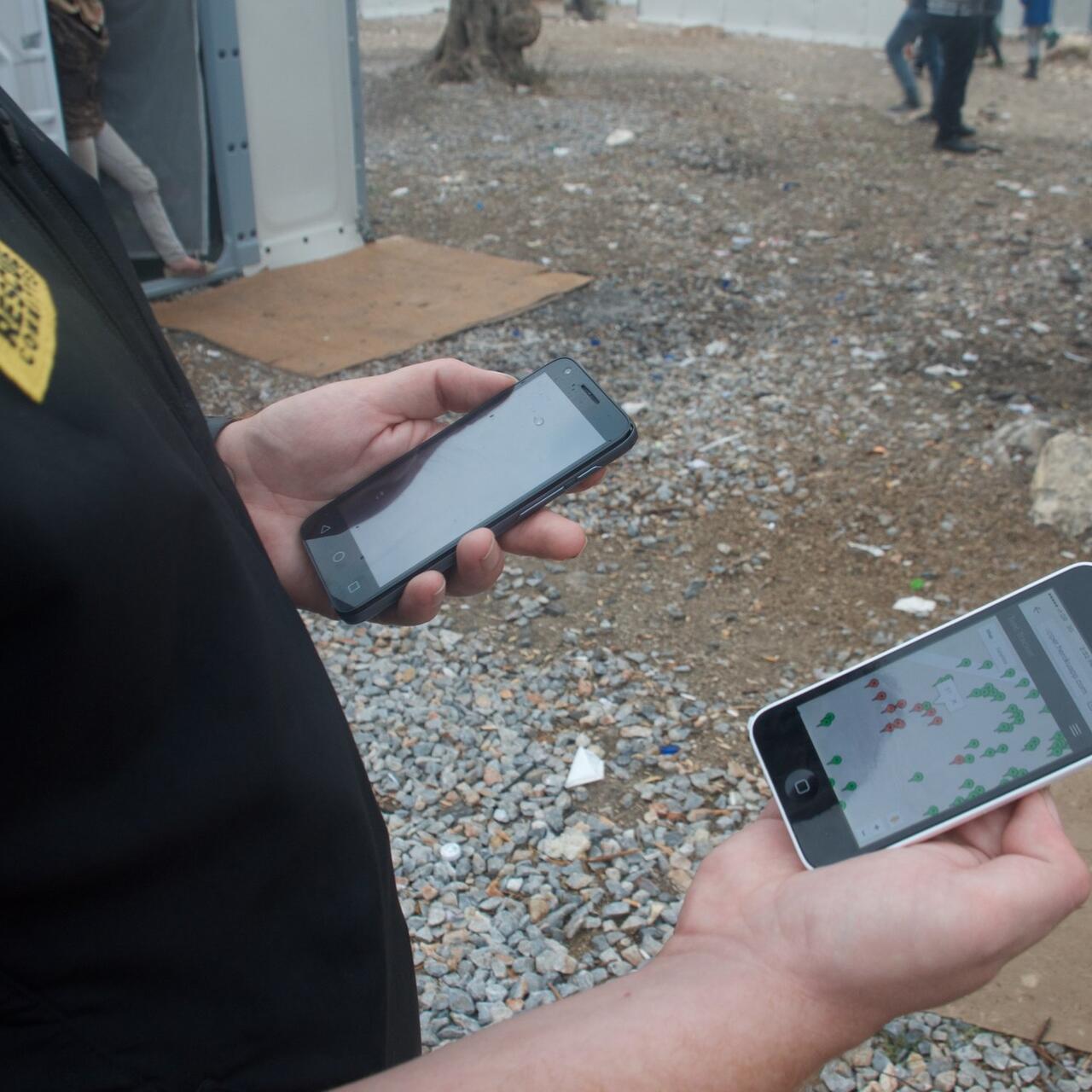 An IRC aid worker in Greece looks at an IRC  shelter mapping app on a smartphone. Photo: Kulsoom Rizvi/IRC
