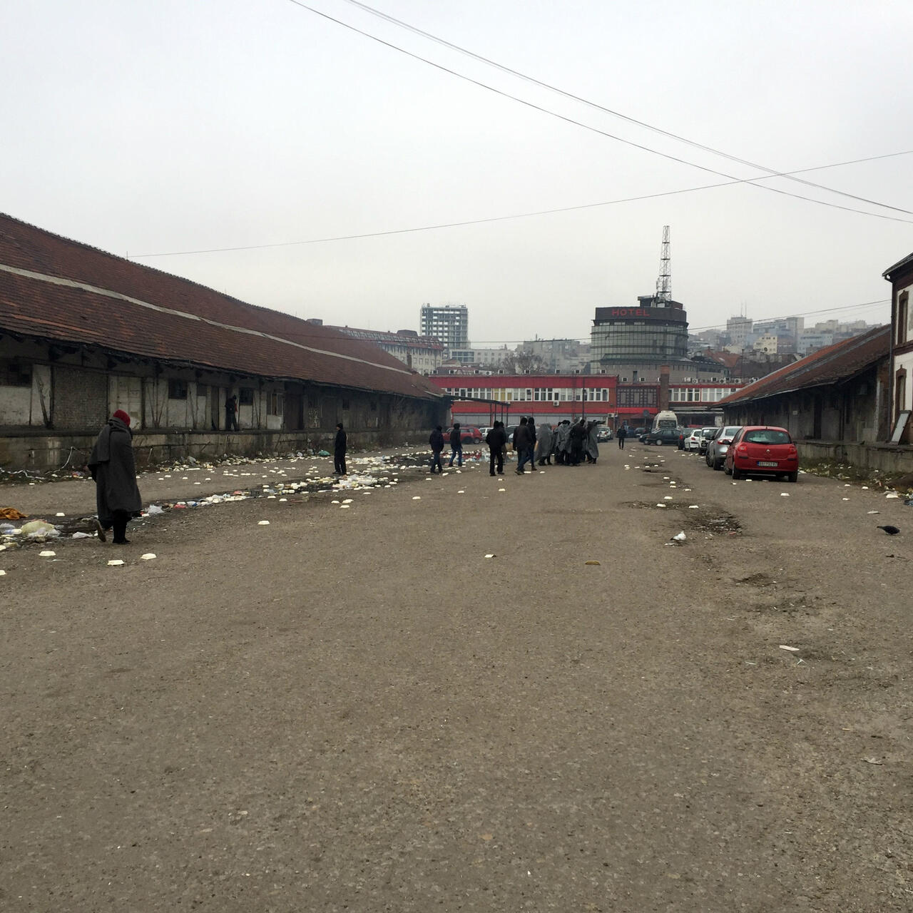 Young refugees wrapped in blankets for warmth gather on the street outside an abandoned warehouse in a Belgrade industrial strip that has become a makeshift shelter.