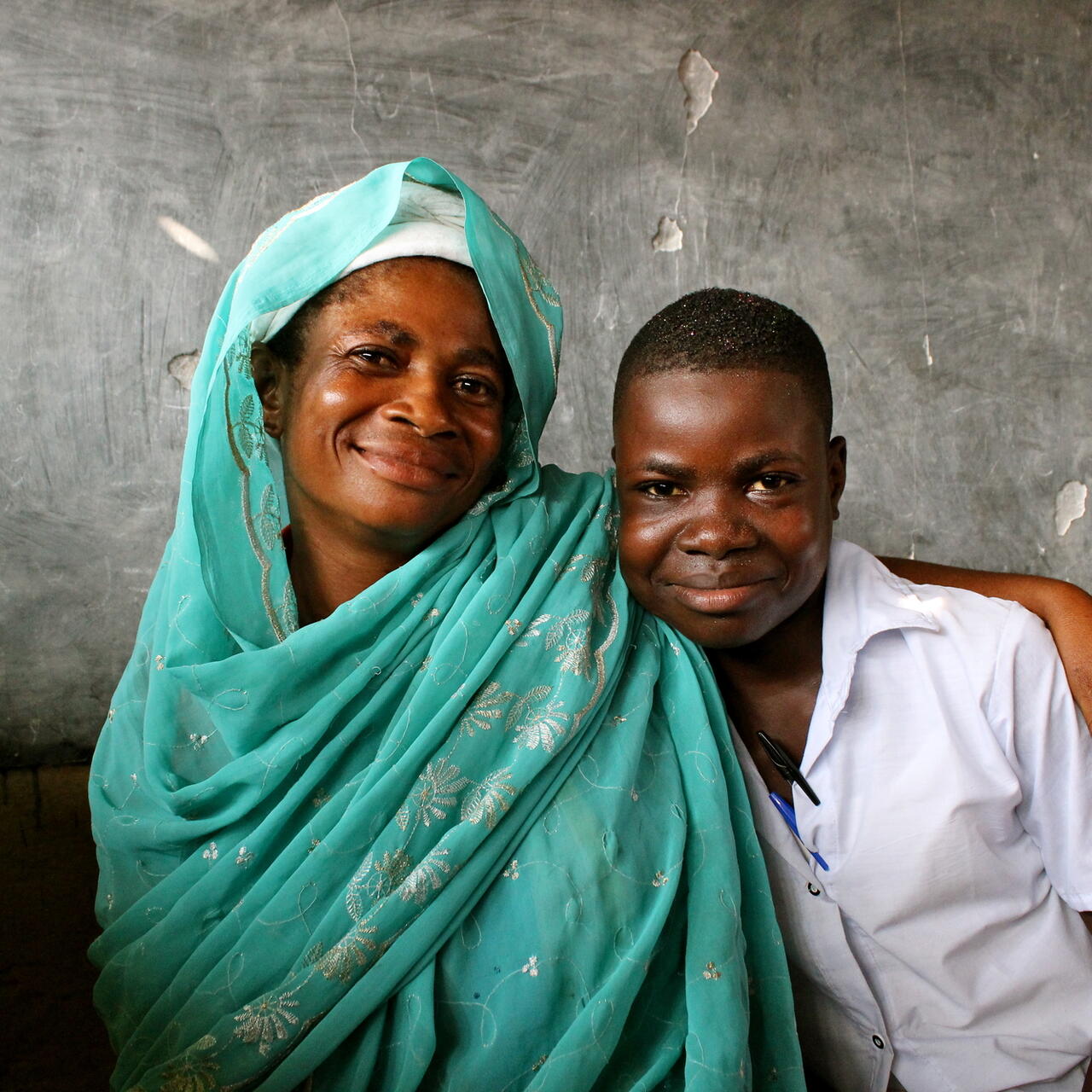 a woman and boy smile at the camera
