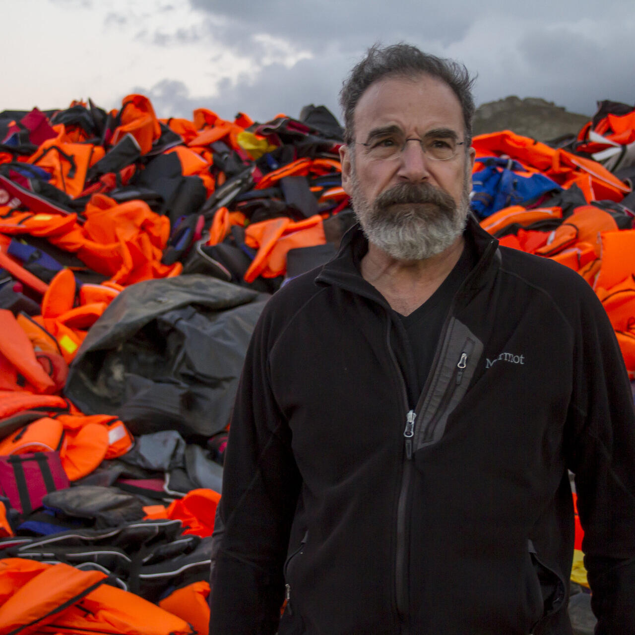 Mandy Patinkin on the island of Lesbos, Greece with lifejackets used by refugee