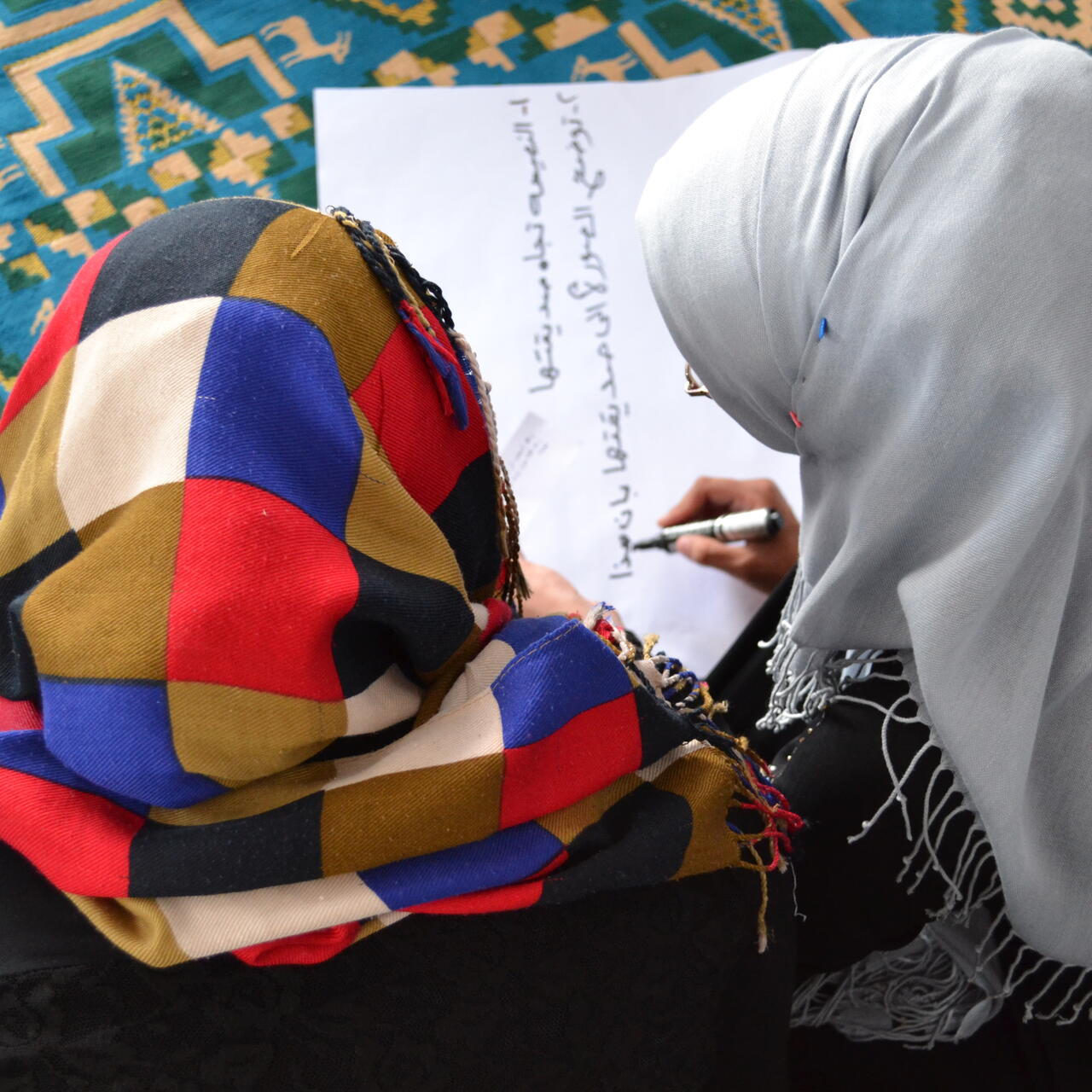 Girls listen in the women's center as IRC social workers explain that every problem has a solution as part of the day's activity