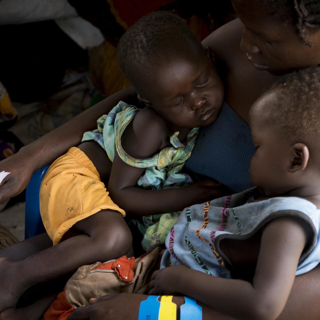 Two-year-old twins, Martin and Desire, sleep on their mother's lap at the registration centre at the Imvepi refugee settlement for South Sudanese who have crossed into northern Uganda, March 3, 2017.