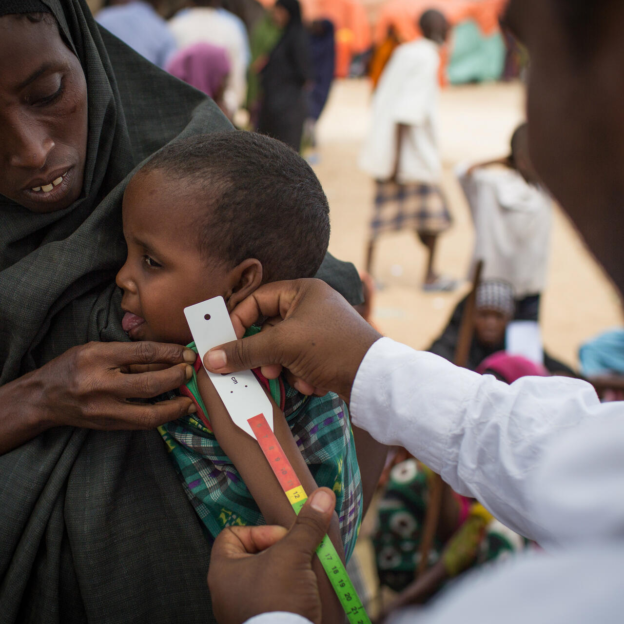 A child is screened for malnutrition using an arm curcumference measurement at an IRC clinic near Mogadishu