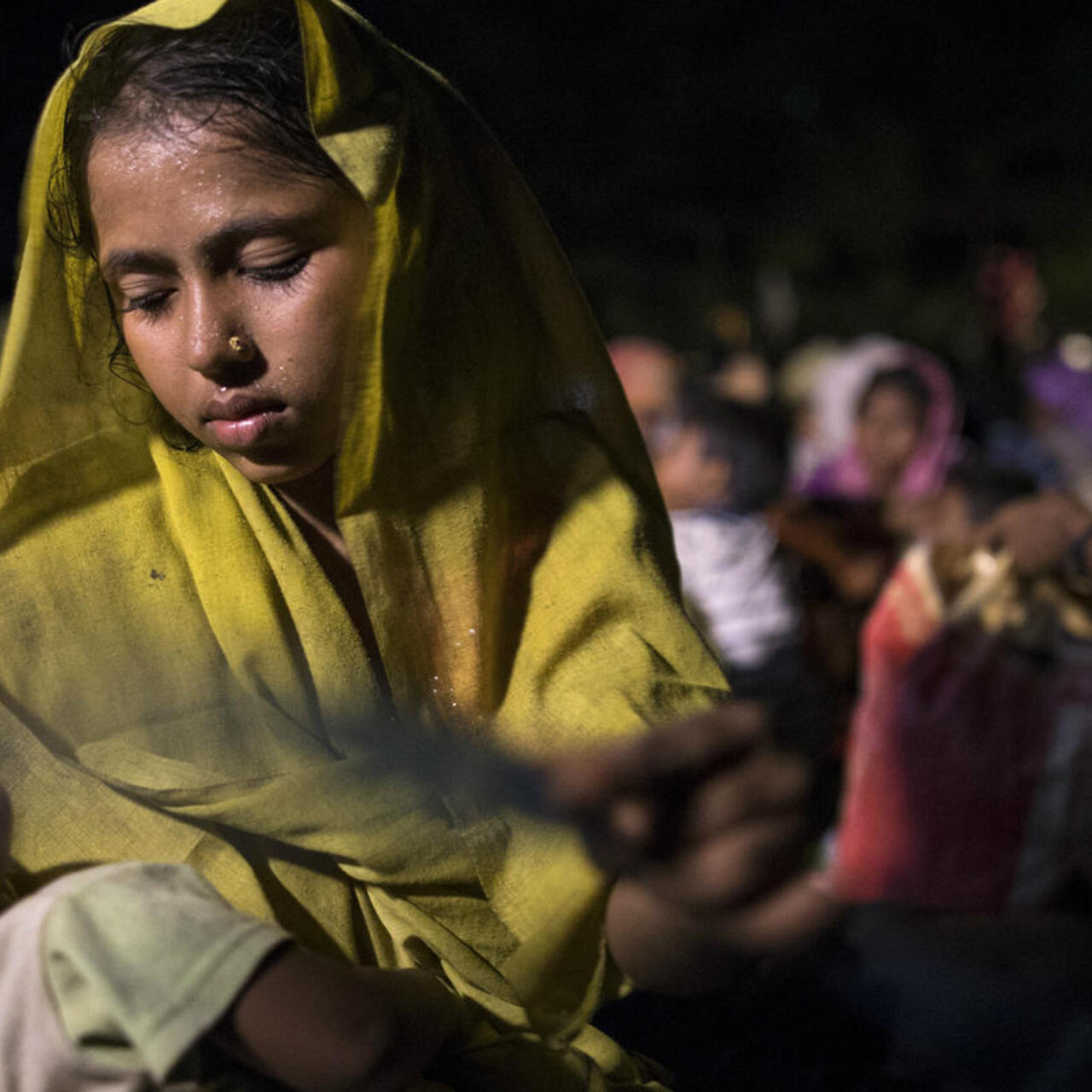 A Rohingya Muslim mother carries her sleeping baby