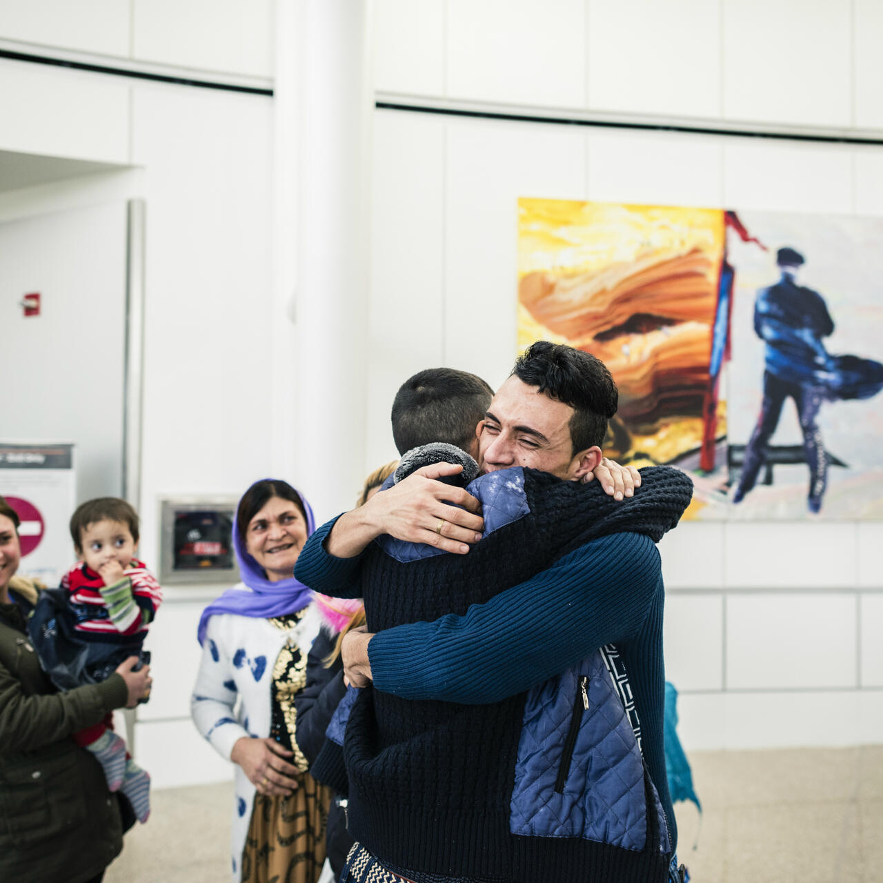 Adil Nimr, a refugee from Iraq, hugs one of his relatives at the airport after arriving in Seattle.