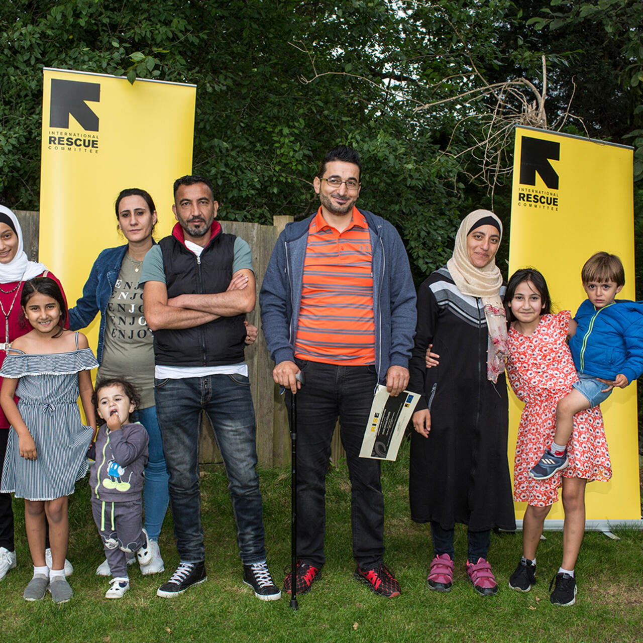 Two families pose together at the first IRC RISE graduation in Horsham, UK.