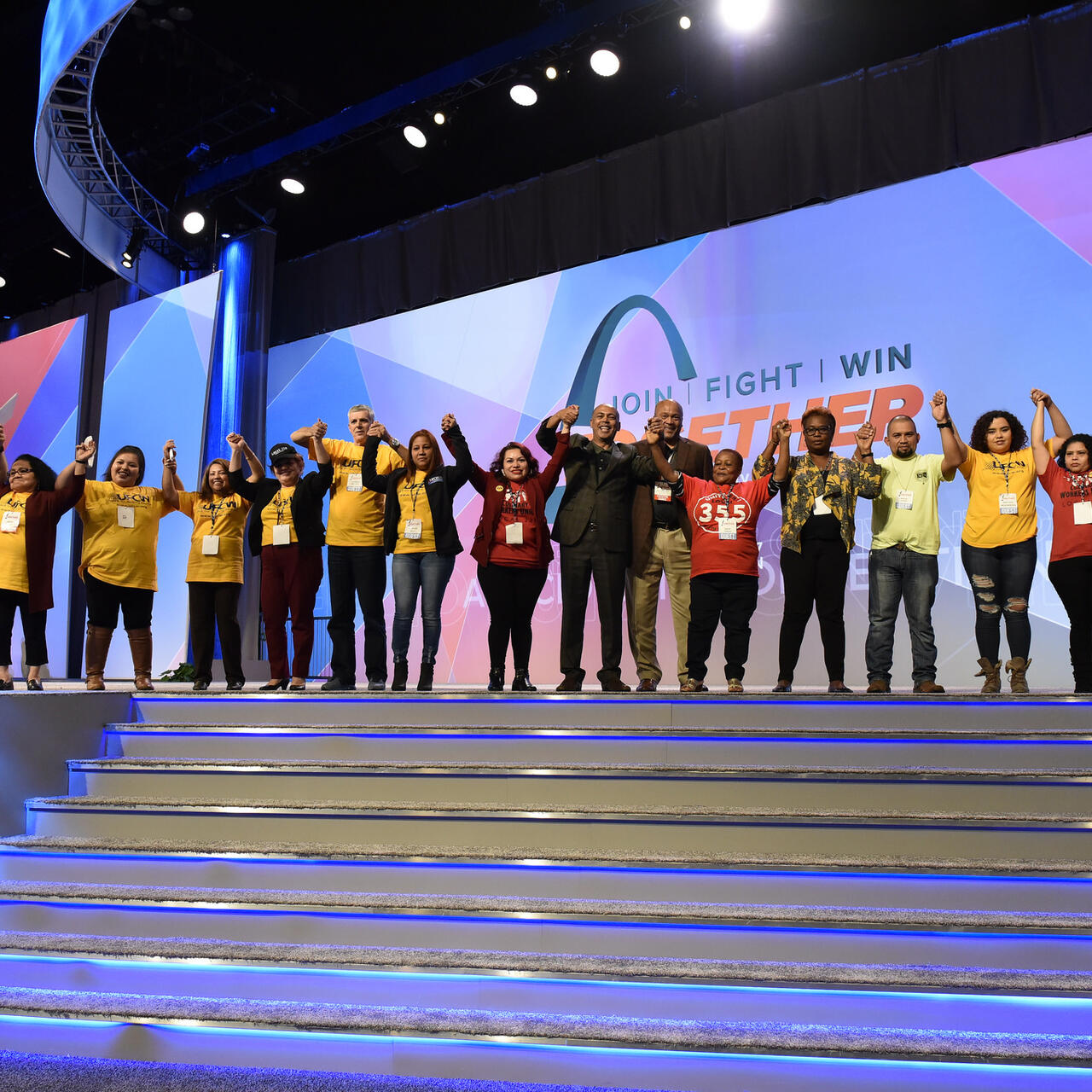 Tefere Gebre stands onstage with a group of new Americans at the AFL-CIO's 2017 conference in St. Louis