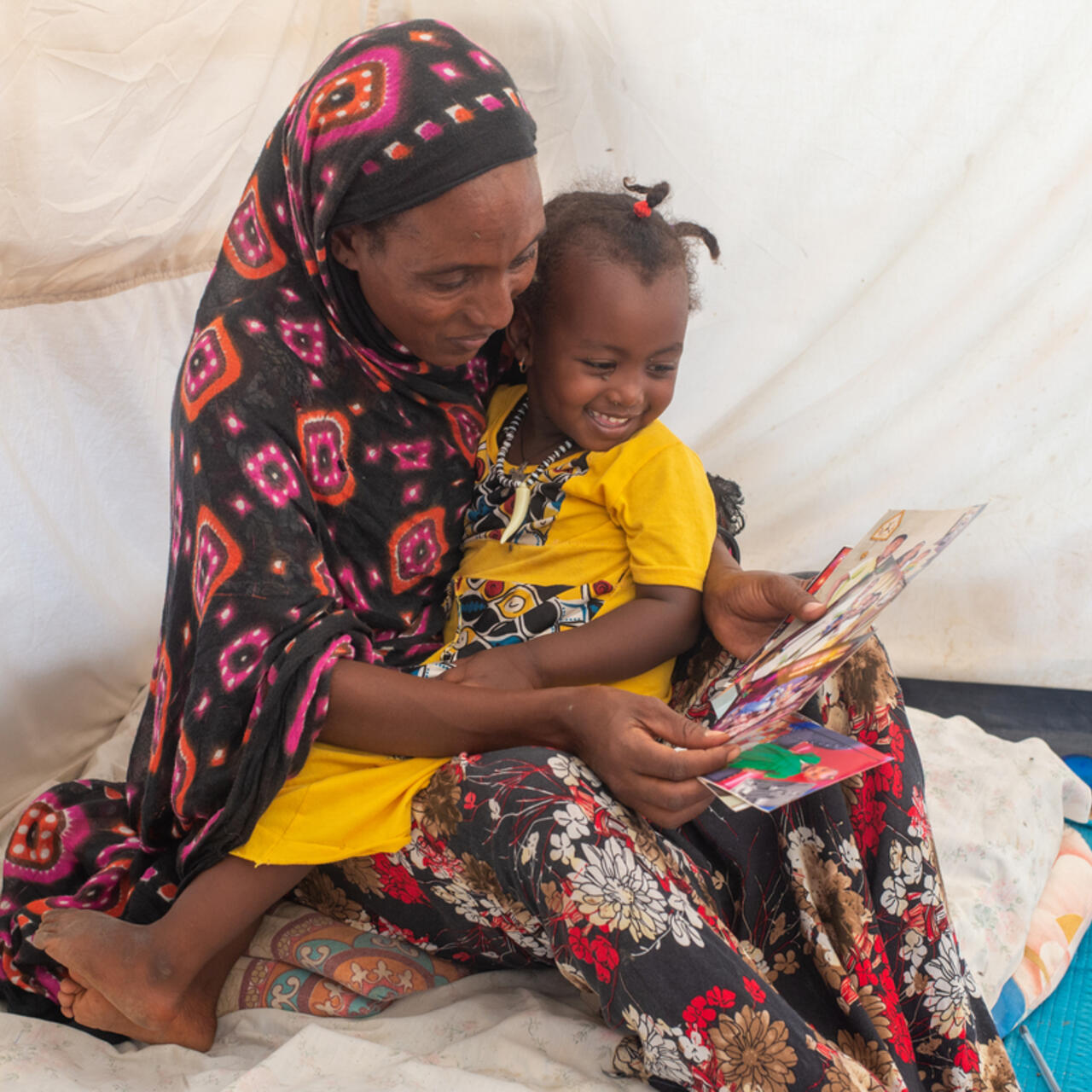Mulu looks at old photographs with her daughter. 