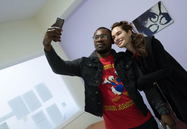 Ein Mann macht ein Foto mit einer Frau, beide lächeln in ein Handy