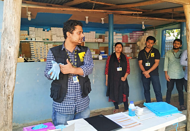 In Cox's Bazar refugee camp in Bangladesh, Dr. Mahmud demonstrates the proper way to put on gloves for health workers and health volunteers.