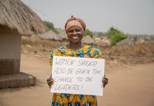 Loyce holds a sign advocating for women's rights in Sierra Leone