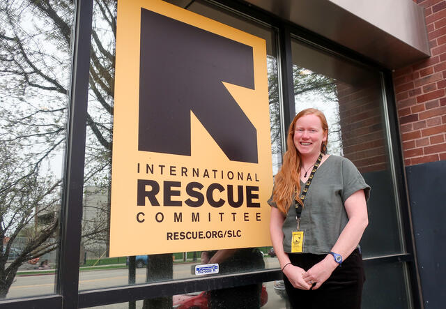 Intern standing in front of company sign.