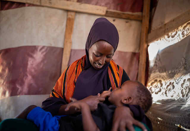 한 엄마가 아기를 먹이고 있습니다.