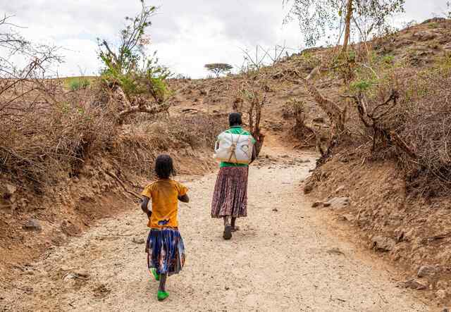 Makito, 40, walks back to the Baide Balbala IDP camp after walking 3 kilometers to fetch water for her family. Along with her daughter, Makito makes this trek at least twice daily to supply her family with water. But the lack of rains and dried waterbeds make it nearly impossible to get enough drinking water.