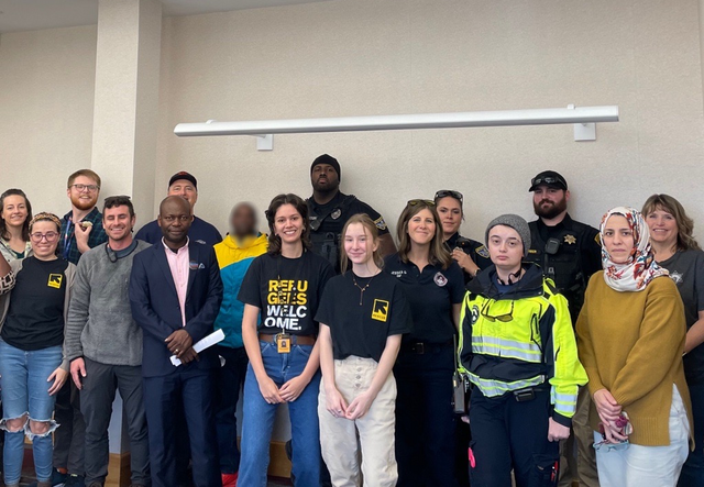 A group of people standing together, some in uniform.