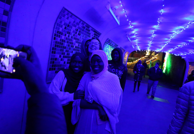 Student Support Specialist Jodi Cantor and Youth Futures students smile for the camera at Garden Lights, Holiday Nights.