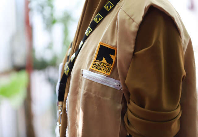 국제구조위원회 로고가 있는 조끼와 명찰을 착용한 스탭의 상반신