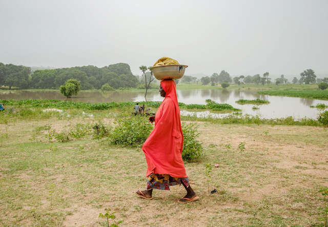 Faiza Habibu carrying bowl of fish on her head