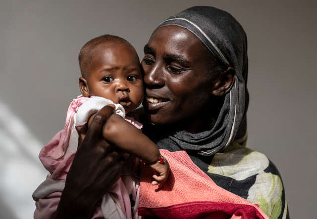 En mamma håller sitt barn i sin famn på en klinik i Tchad.