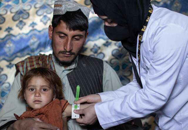 A young child is screened for signs of malnutrition by a member of an IRC mobile health team in rural Afghanistan.