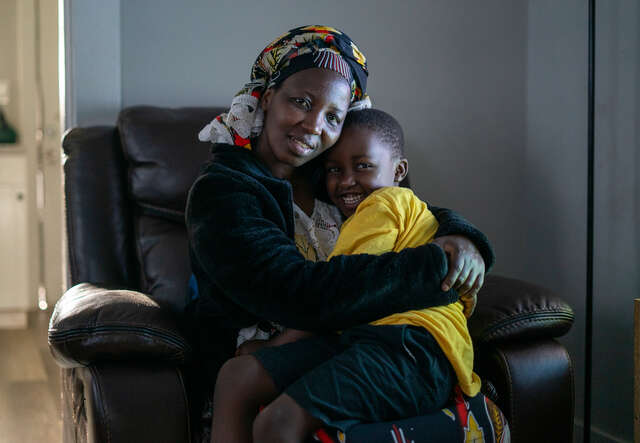 본필의 어머니, 냐베자 냐비가지가 아들과 함께 앉아 그를 안고 있습니다.