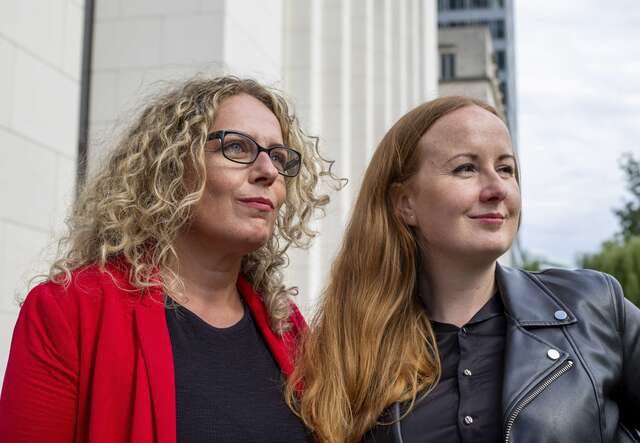 Zwei Frauen schauen in die Ferne, im Hintergrund die Stadt.