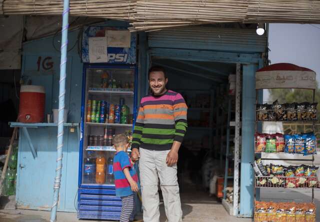 Ein Mann und ein Kind stehen vor einem Geschäft