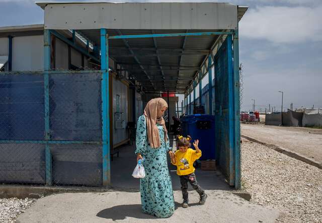 Eine syrische Mutter und ihre Tochter verlassen ein Gebäude.