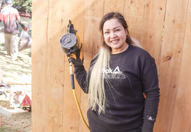 Victoria stands proudly in front of one of her custom built residential fences.