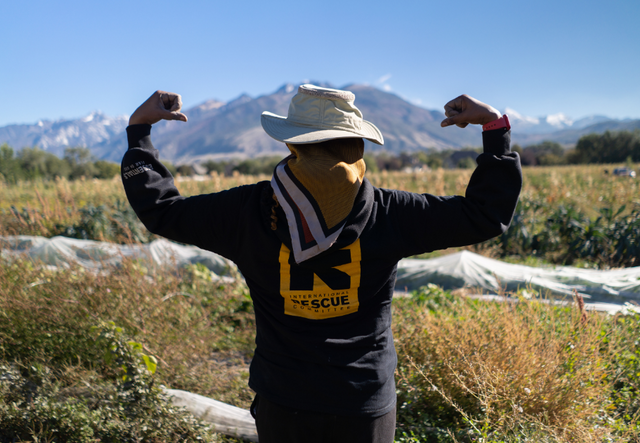 Person in IRC shirt facing away from camera with arms outstretched.