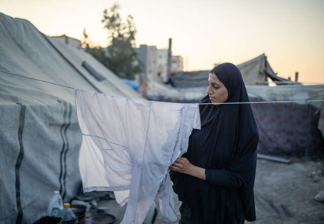 한 소녀가 빨랫줄에 빨래를 널고 있습니다.
