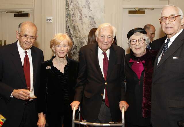 Five people standing together and smiling into the camera