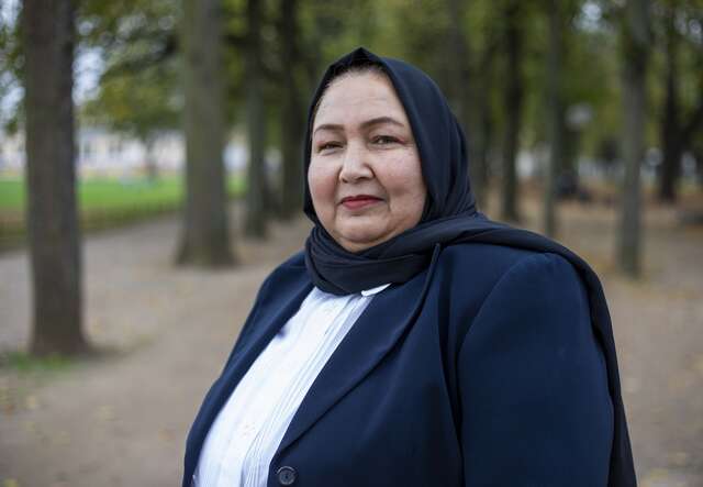 Porträt einer afghanischen Frau in Deutschland, aufgenommen in einer ruhigen Parklandschaft.