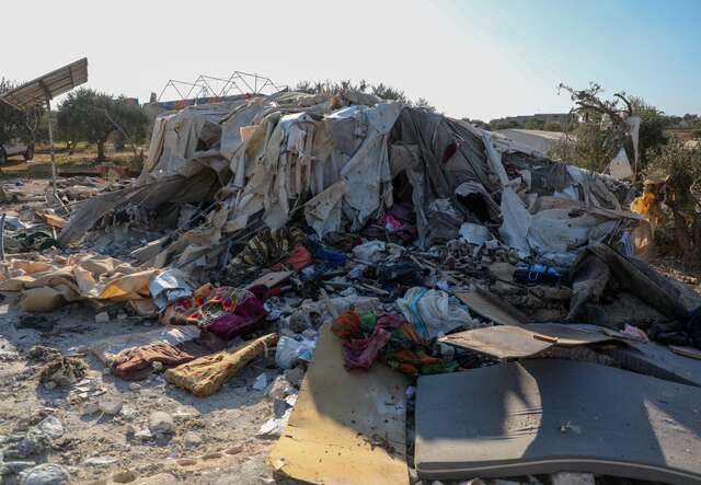 시리아 하르바누쉬의 한 캠프가 공습을 받은 후, 소지품들이 불에 탄 채로 남아 있는 난민 텐트 잔해.