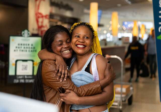Two sisters embrace after they are reunited at an airport in the U.S.