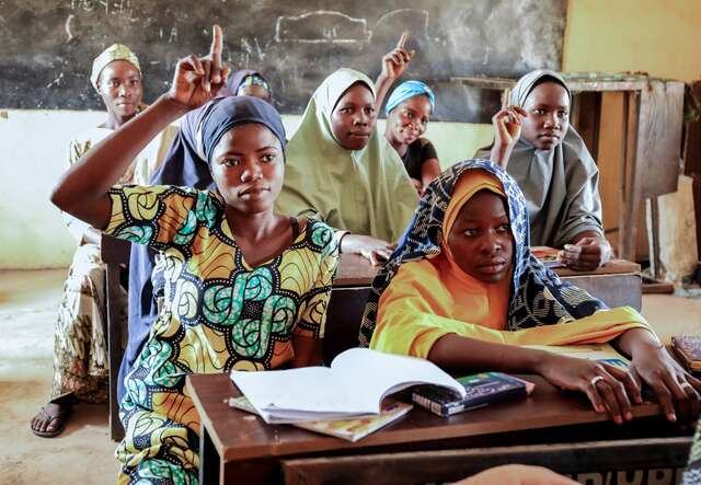 나이지리아의 한 교실에서 여학생들이 손을 들고 수업에 적극적으로 참여하고 있습니다.