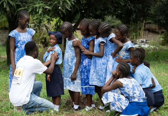 An IRC staff member delivers vaccinations to students in Sierra Leone.