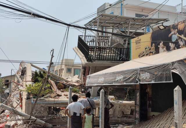 미얀마 지진 현장에서 사람들이 무너져내린 잔해를 바라보고 있습니다