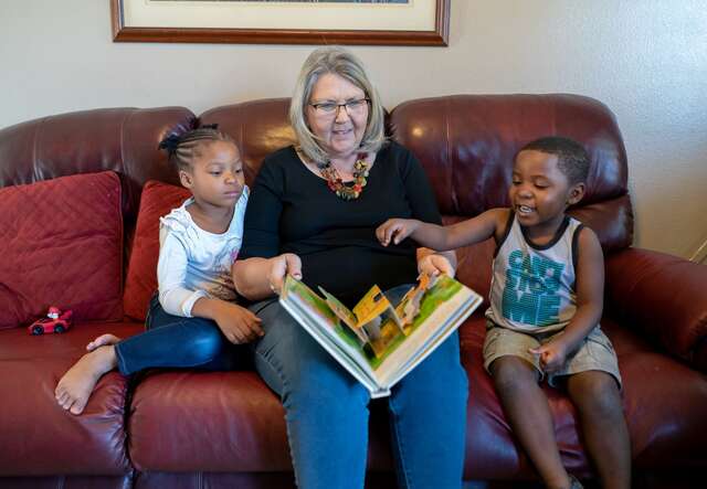 IRC worker reading with children on the couch