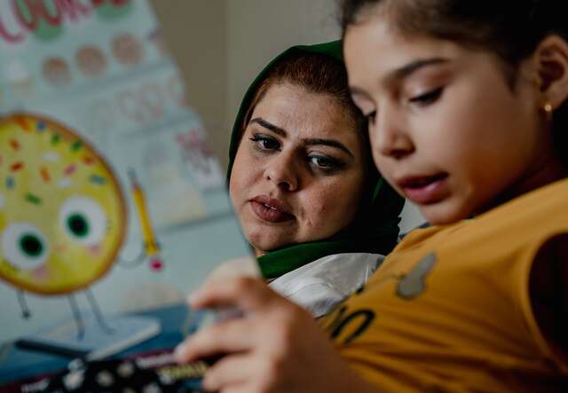 Adult and child reading together