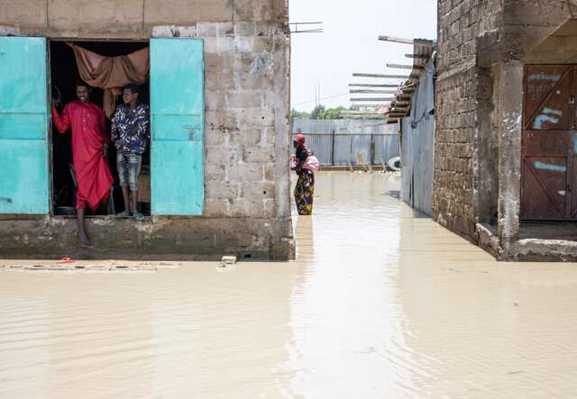 En man i Tchad försöker ta sig ut ur sitt hus som översvämmats efter säsongens första stora regn.