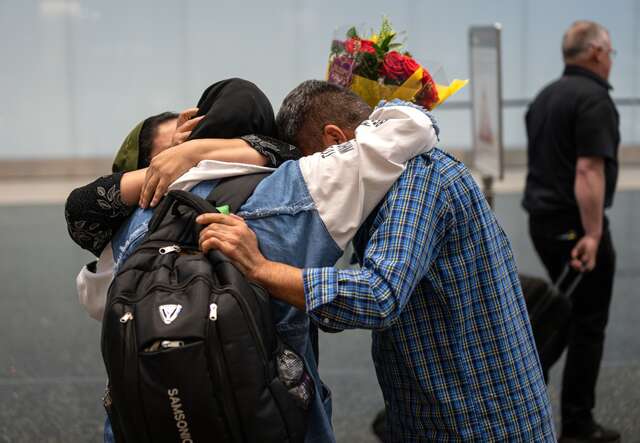 An Afghan family embraces as they are reunited in a U.S. airport.
