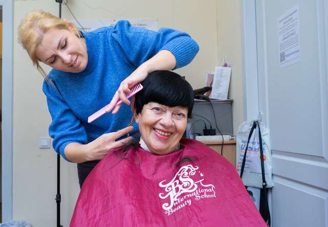 안나가 한 여성의 머리를 자르고 있습니다. 