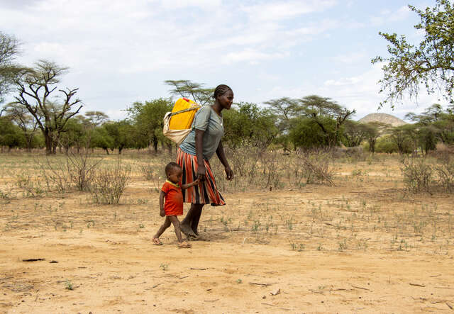 Kvinna med barn går hem efter att ha hämtat vatten vid en vattenpump som RESCUE byggt in i torkdrabbde Etiopien.