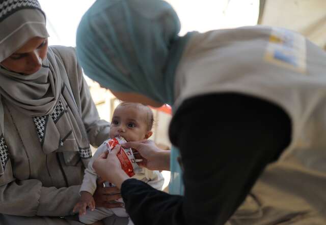 An IRC staff member treats a young Palestinian child for signs of malnutrition.