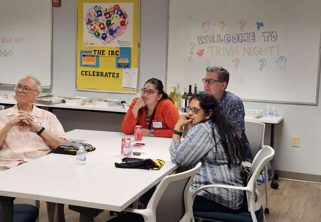 Table of 4 individuals reflecting on trivia answers