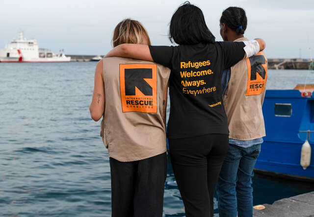 Tre personer i RESCUE-västar vid en hamn i Italien. RESCUE ger skydd och stödd till människor som överlevt resan över Medelhavet.